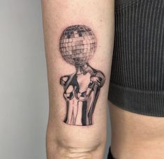 a woman's arm with a disco ball tattoo on it