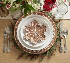 a table set with silverware and christmas decorations