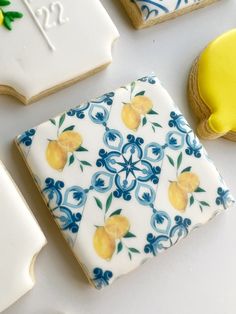 decorated cookies with lemons and blue designs on them are sitting next to each other