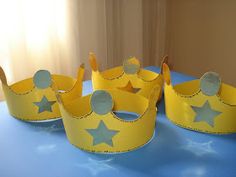 three yellow crowns sitting on top of a blue table