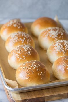 small rolls with sesame seeds on top in a baking pan ready to go into the oven