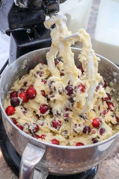 a metal bowl filled with batter and cranberries