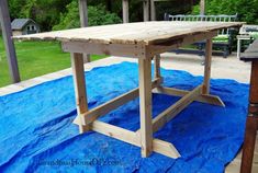 a wooden table sitting on top of a blue tarp