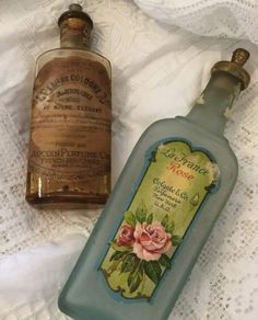 two old fashioned bottles sitting on top of a bed