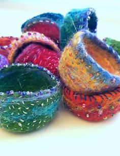 there are many different colored bowls on the table with bead sprinkles