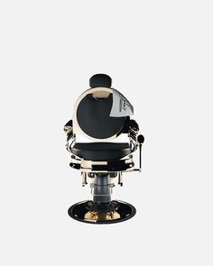 a black and white barber chair with gold trimmings on the back, in front of a white background