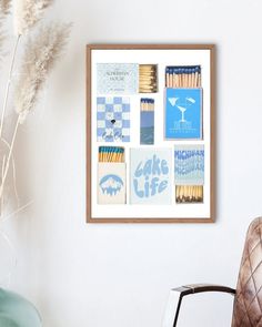 a chair sitting next to a white wall with pictures on it and a plant in the corner