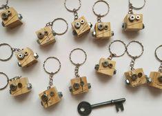 a bunch of wooden key chains with eyes and keys attached to them, sitting on a table