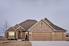 a brick house with two garages in the front yard