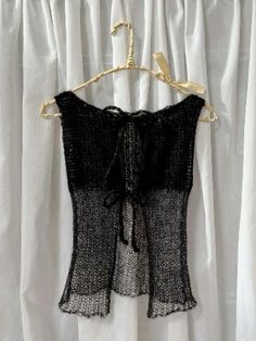 a black and white top hanging on a curtain