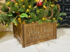 a christmas tree in a wooden box with lights around it and merry christmas the remold family