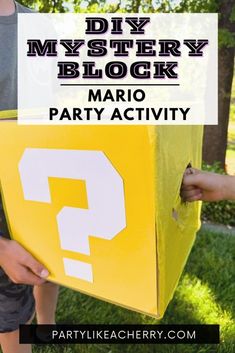 a person holding a yellow box with question mark on it and the text diy mystery block mario party activity