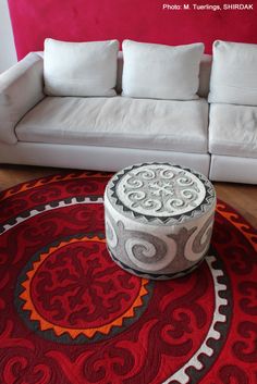 a white couch sitting on top of a red rug