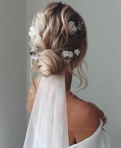 the back of a woman's head wearing a veil and flowers in her hair