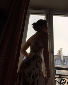 a woman standing in front of a window