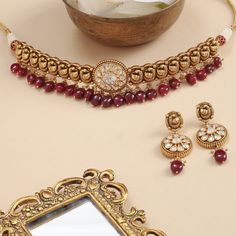 Description An opulent choker fit for a bride, this intricate gold plated silver neckpiece is the definition of regalia. A sequence of Mayurs have been expertly crafted out of the traditional Nakshi technique. This head-turner also features a moissanite studded center motif sparkling like the sun. Semi-precious rubies and pearl clusters add a royal charm to this choker set that come with an equally stunning set of drop earrings. Product Information Materials used: 925 Silver with Antique Gold Pl Pearl Cluster, Choker Set, Silver Choker, Gold Plated Silver, Antique Gold, Semi Precious, Choker, 925 Silver, Gold Bracelet