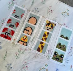 four cross stitch squares with animals on them