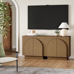 a large flat screen tv mounted to the side of a wooden cabinet in a living room