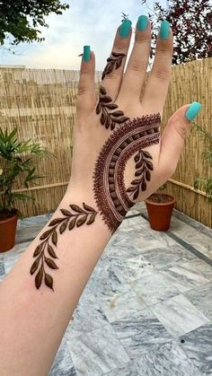 a woman's hand with henna tattoos on it