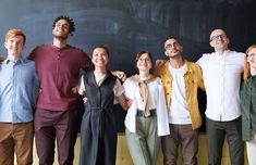 a group of people standing in front of a blackboard