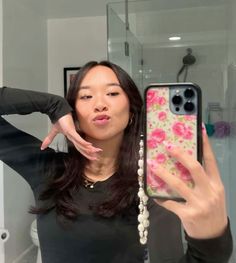 a woman taking a selfie in front of a bathroom mirror with her phone case