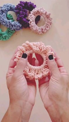 two hands holding crocheted rings in front of them