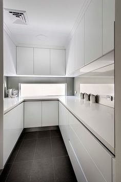 an empty kitchen with white cabinets and counter tops