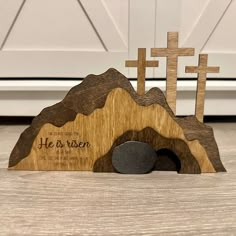 a wooden church with three crosses on top of it and the words he is risen