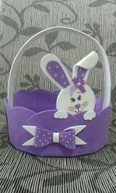 a purple basket with a white rabbit in the center and a bow tie on it