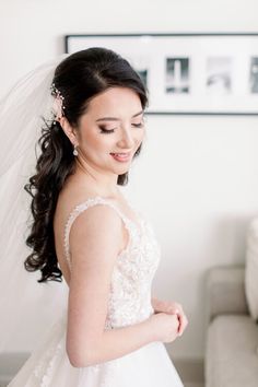 a woman in a wedding dress is smiling at the camera while standing next to a couch