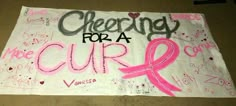 a sign with pink ribbon and writing on it that says cheering for a cupcake