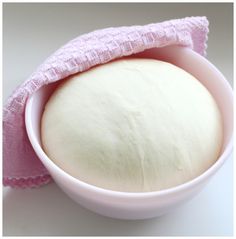 a bowl with a pink cloth on it and a ball of bread in the middle