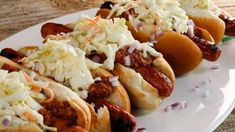 several hot dogs with toppings on a plate