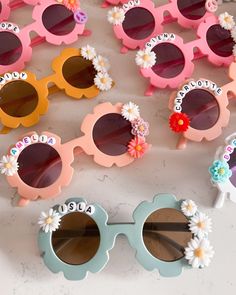 several pairs of sunglasses with flowers on them sitting next to each other in the shape of sun glasses