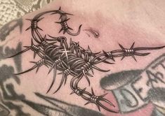 a close up of a tattoo with barbed wire on the side of a man's chest