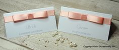 two wedding cards with pink bows and pearls