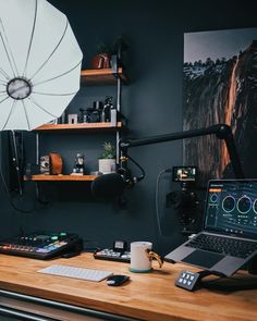 a laptop computer sitting on top of a wooden desk next to a white parasol