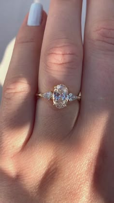 a woman's hand with a ring on it and a diamond in the middle