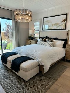 a large bed sitting in a bedroom next to a window