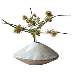 a white vase with some flowers in it