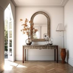 an empty room with a mirror, vase and lamp on the side table in front of it