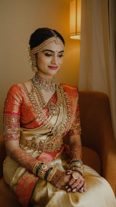 a woman sitting on top of a chair in a bridal gown and jewelry set