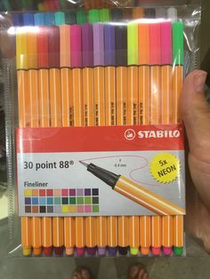 a person holding up a pack of stabio fineliners