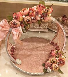 an elaborately decorated tray with pink flowers and pearls on the edge is sitting on a table