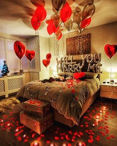 a bedroom decorated for valentine's day with lots of red hearts floating from the ceiling