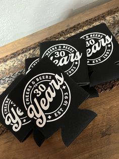 three black stickers with white lettering are on a wooden countertop next to a rug