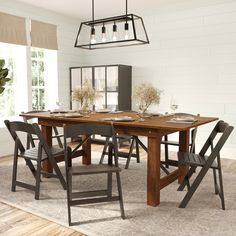 a dining room table with chairs and a light hanging from the ceiling over it, in front of a large window