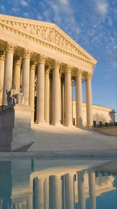 the supreme court building in washington, d c is reflected in a pool of water