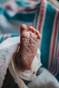 a close up of a baby's foot on a blanket