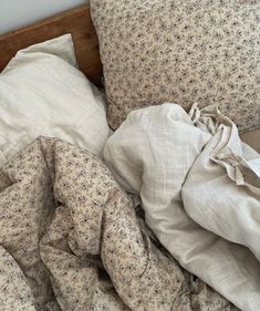 an unmade bed with sheets and pillows